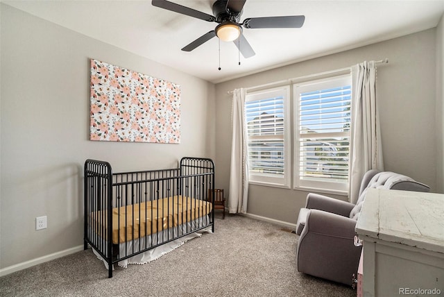 carpeted bedroom with a nursery area and ceiling fan