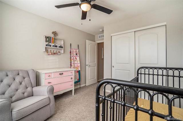 carpeted bedroom with ceiling fan and a closet