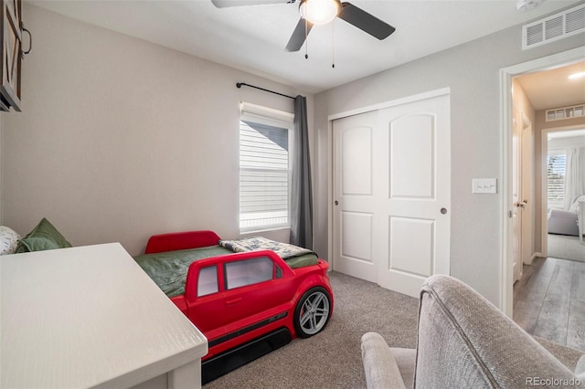 bedroom featuring light carpet, a closet, and ceiling fan