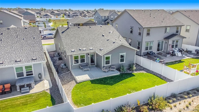 rear view of house featuring a patio area and a yard