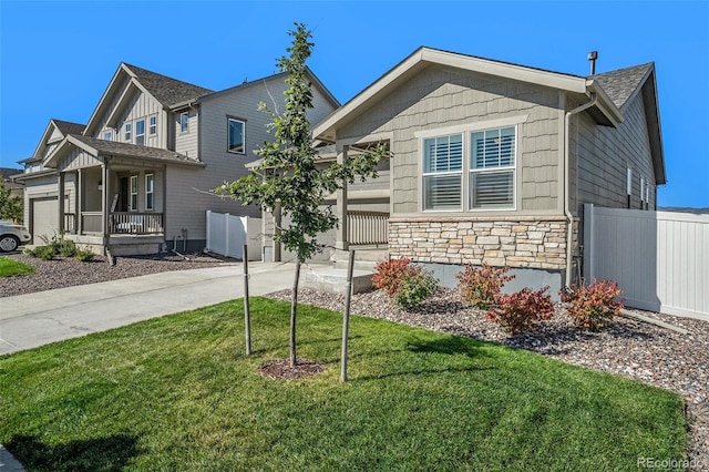 view of front of property with covered porch, a front lawn, and a garage