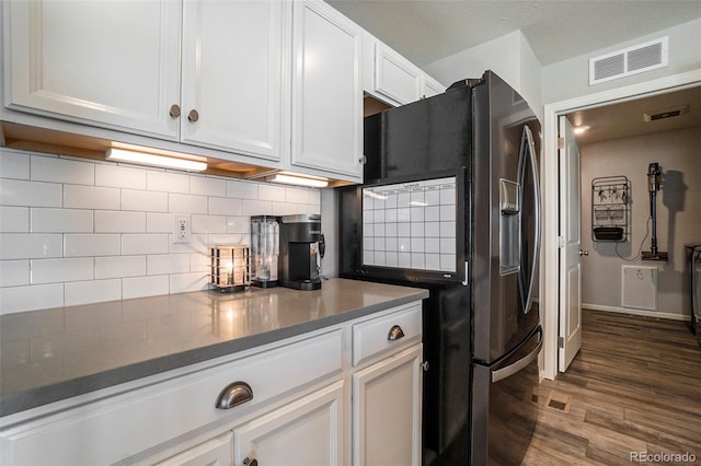 kitchen with backsplash, dark hardwood / wood-style floors, black fridge with ice dispenser, and white cabinets