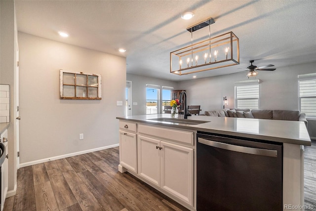 kitchen with decorative light fixtures, dishwasher, sink, white cabinets, and a kitchen island with sink