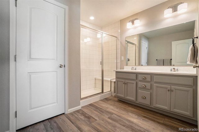 bathroom with an enclosed shower, vanity, and hardwood / wood-style flooring