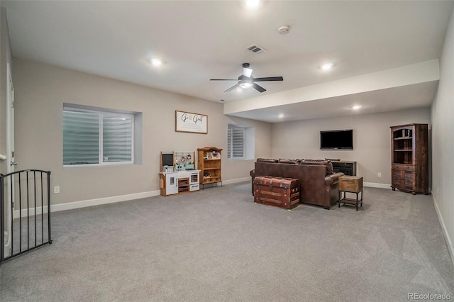 carpeted living room with ceiling fan