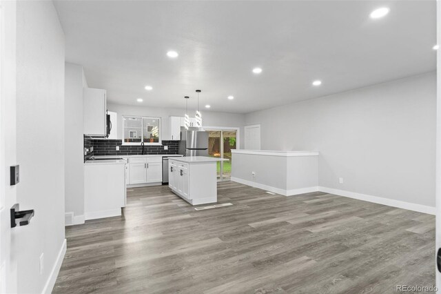 4672 S Lewiston Way, Aurora, CO 80015 - kitchen with stainless steel appliances, backsplash, white cabinetry, recessed lighting, and a center island