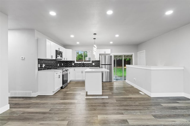 4672 S Lewiston Way, Aurora, CO 80015 - kitchen with stainless steel appliances, a sink, recessed lighting, decorative backsplash, and white cabinets