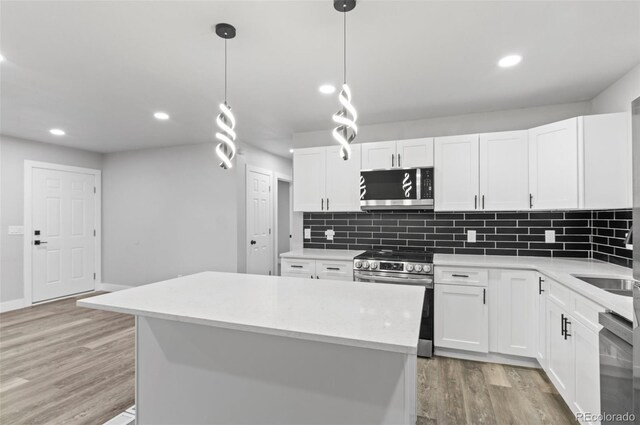 4672 S Lewiston Way, Aurora, CO 80015 - kitchen featuring stainless steel appliances, light wood-type flooring, tasteful backsplash, white cabinets, and recessed lighting