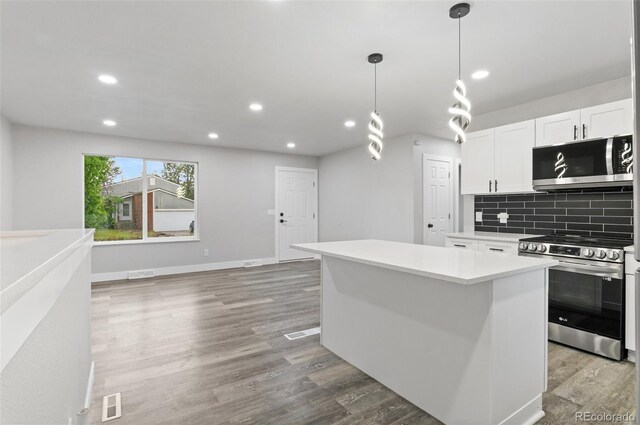 4672 S Lewiston Way, Aurora, CO 80015 - kitchen featuring stainless steel appliances, light countertops, recessed lighting, backsplash, and a center island