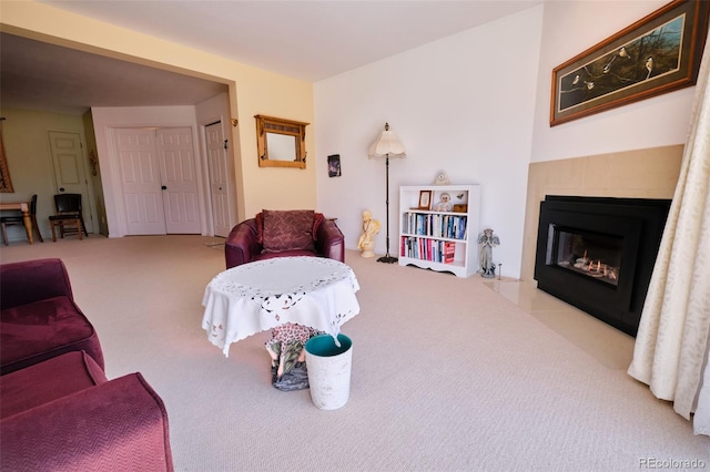 living room with carpet and a fireplace with flush hearth