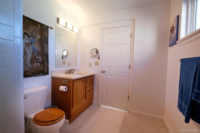 bathroom featuring toilet, tile patterned floors, baseboards, and vanity