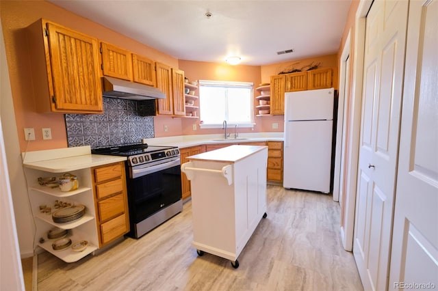 kitchen with under cabinet range hood, light countertops, freestanding refrigerator, stainless steel electric stove, and open shelves