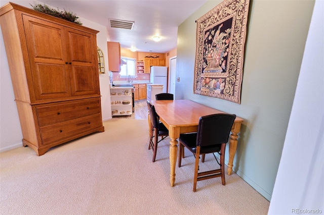 dining space featuring light carpet, visible vents, and baseboards