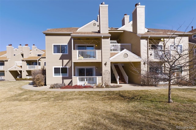 rear view of house with a yard and stairs