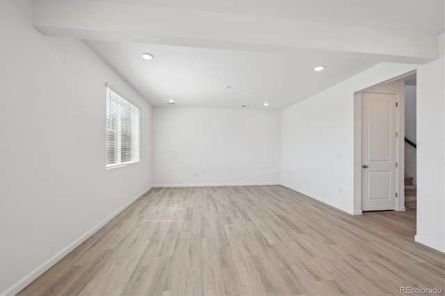 spare room with baseboards, stairs, and light wood-type flooring