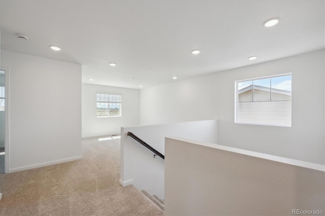hall featuring light carpet, baseboards, an upstairs landing, and recessed lighting