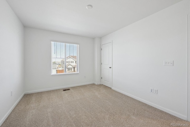 spare room with baseboards, visible vents, and carpet floors