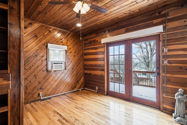 interior space featuring ceiling fan, cooling unit, wooden walls, wood ceiling, and light wood-type flooring