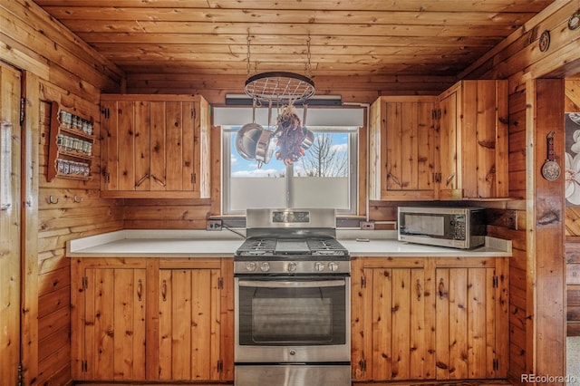 kitchen with appliances with stainless steel finishes, brown cabinetry, and light countertops