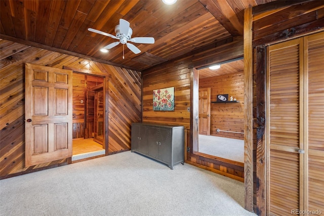 unfurnished bedroom featuring light carpet, wood ceiling, and wooden walls