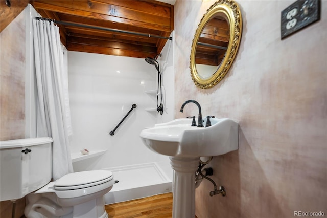 full bath featuring a stall shower, toilet, and wood finished floors