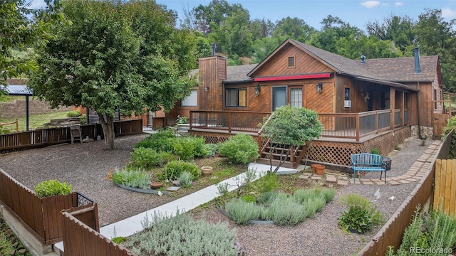 133 N 13th St, Colorado Springs, CO 80904 - back of house featuring a wooden deck, a fenced backyard, roof with shingles, and a chimney
