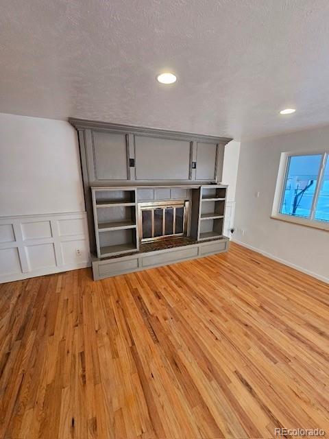 interior space with a textured ceiling and hardwood / wood-style flooring