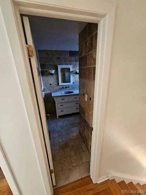 interior space featuring decorative backsplash, wood-type flooring, and vanity