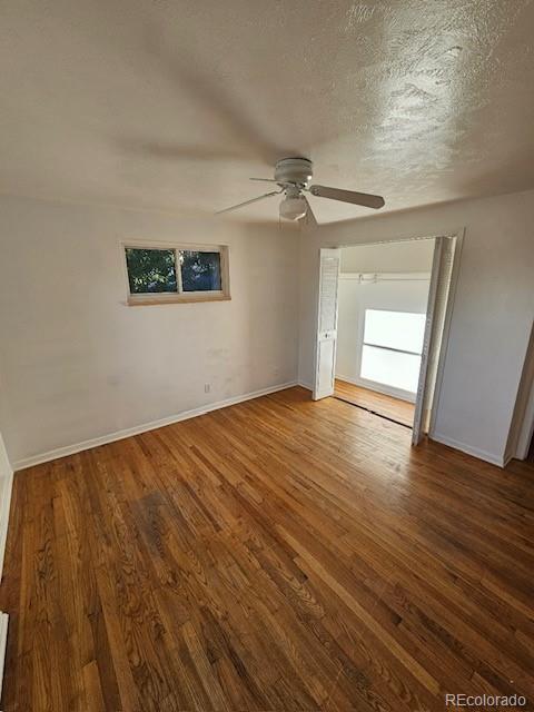 unfurnished room with ceiling fan, a textured ceiling, and wood-type flooring