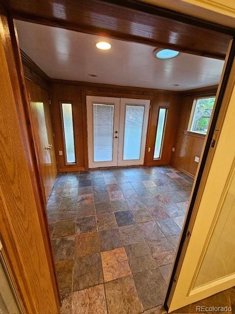 entrance foyer with wood walls and french doors