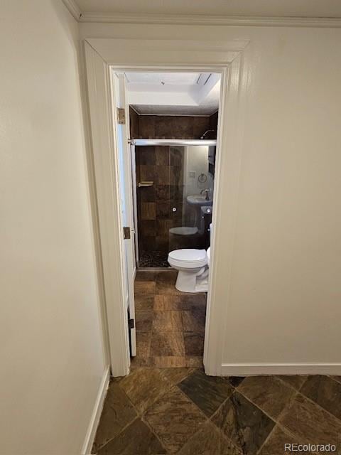 bathroom featuring walk in shower, ornamental molding, and toilet