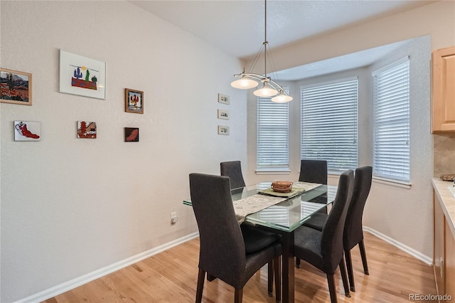 dining room featuring light wood-style flooring and baseboards