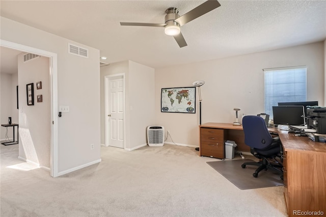 office area with baseboards, visible vents, light carpet, and a textured ceiling