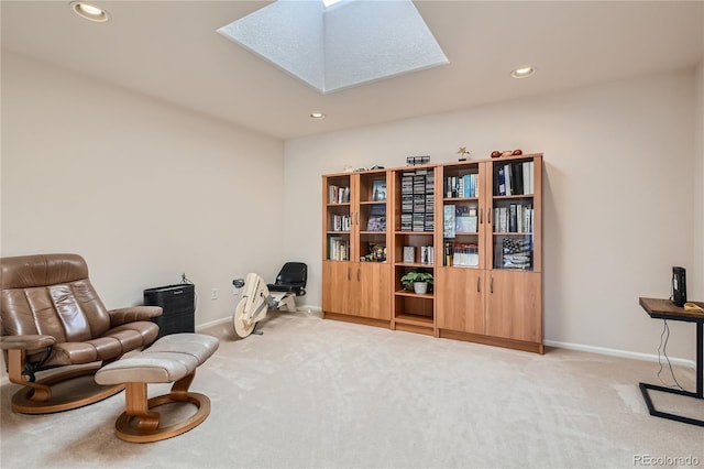 sitting room with a skylight, recessed lighting, baseboards, and light colored carpet