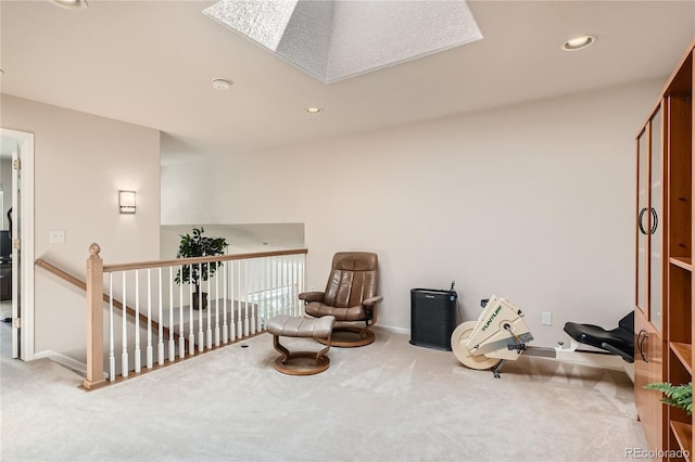 sitting room with a skylight, carpet flooring, an upstairs landing, and recessed lighting