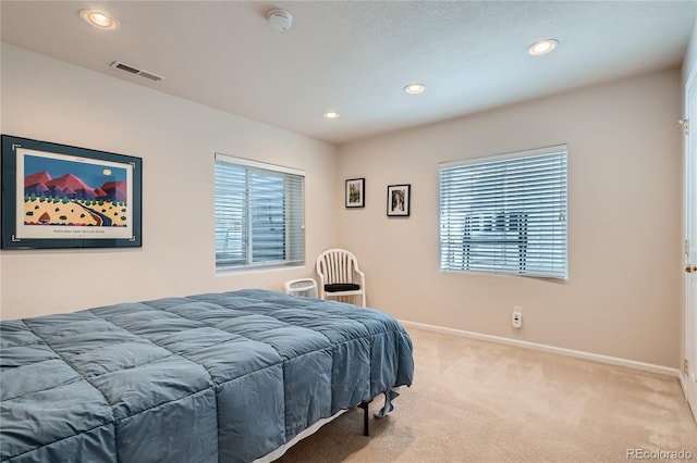 bedroom with baseboards, visible vents, carpet flooring, and multiple windows