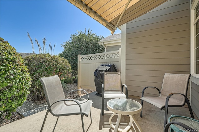 view of patio featuring fence and a grill