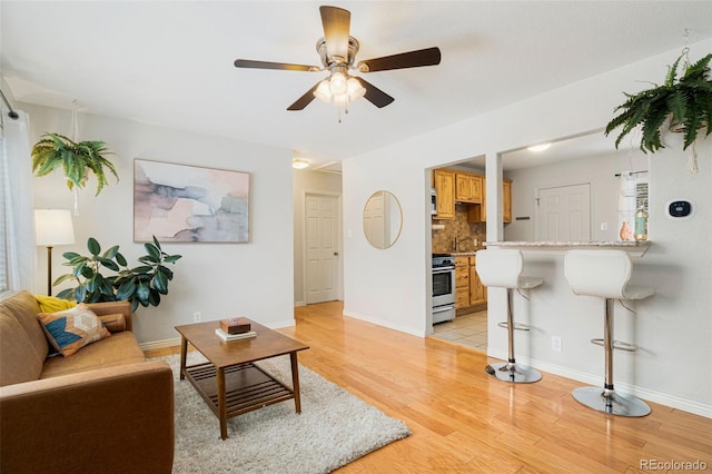 living room with light wood-type flooring and ceiling fan