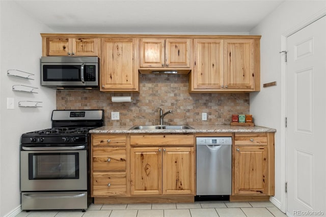 kitchen with decorative backsplash, sink, light tile patterned flooring, and stainless steel appliances