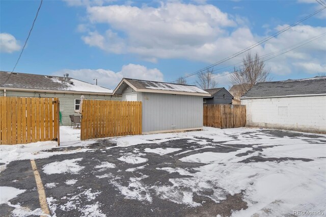 snowy yard featuring a storage unit