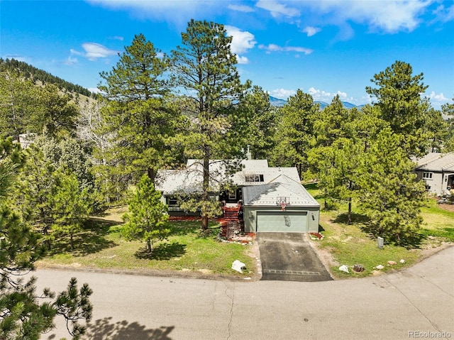 view of front of home with an attached garage, driveway, and a front lawn