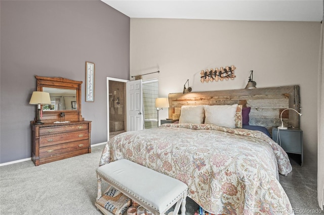 carpeted bedroom featuring baseboards and high vaulted ceiling