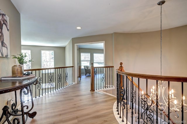 7329 Arco Iris Ln, Castle Pines, CO 80108 - hallway featuring wood finished floors, plenty of natural light, an upstairs landing, recessed lighting, and a chandelier