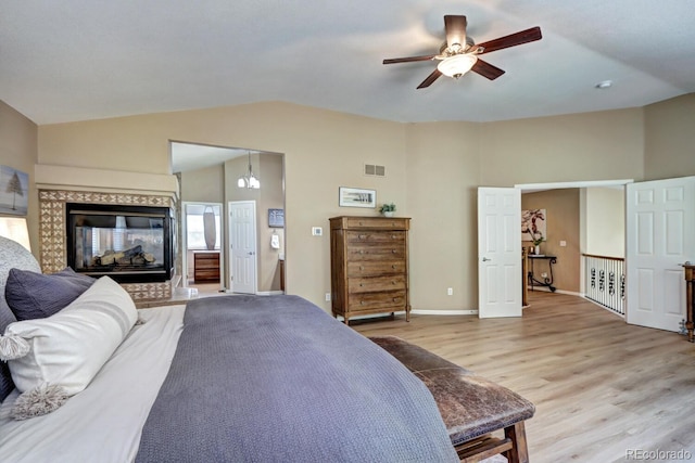 7329 Arco Iris Ln, Castle Pines, CO 80108 - bedroom featuring light wood-style floors, a tile fireplace, high vaulted ceiling, a ceiling fan, and ensuite bath