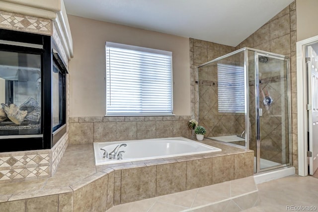 7329 Arco Iris Ln, Castle Pines, CO 80108 - bathroom featuring a bath, a stall shower, tile patterned flooring, vaulted ceiling, and a tile fireplace
