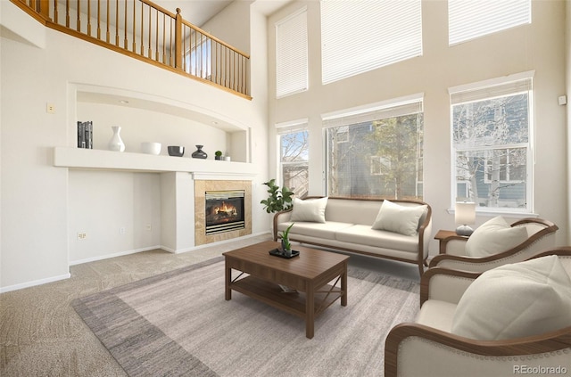 living room with a tiled fireplace, a towering ceiling, and carpet floors