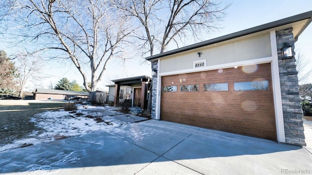 snow covered property with a garage