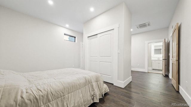 bedroom with dark hardwood / wood-style floors and a closet