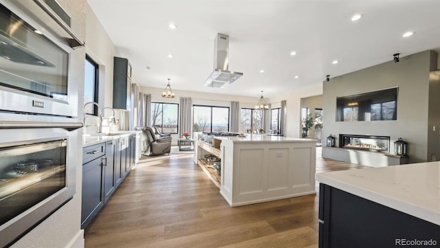 kitchen with a notable chandelier, light stone countertops, sink, and decorative light fixtures