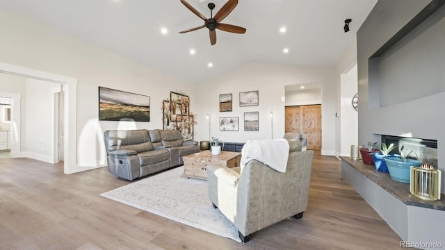 living room with vaulted ceiling, ceiling fan, and hardwood / wood-style flooring